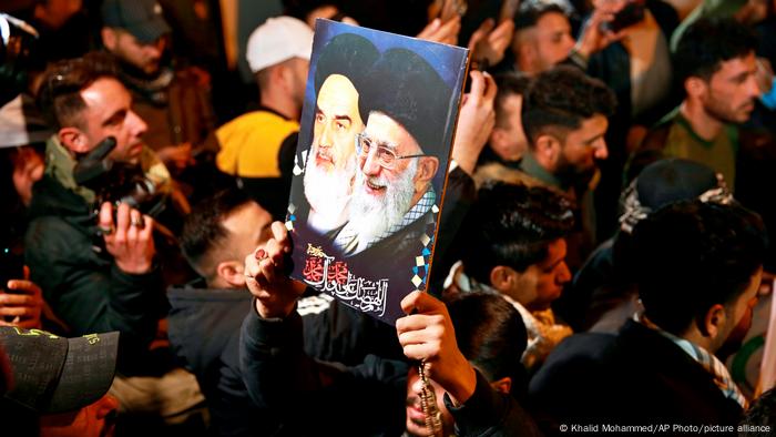 Members of the Popular Mobilization Forces carry pictures of senior Iranian clergy during a demonstration. 