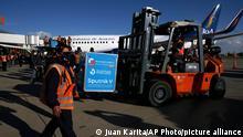 Airport employees unload the first shipment of Russia's Sputnik V COVID-19 vaccine after it arrived at the international airport in El Alto, Bolivia, Thursday, Jan. 28, 2021. (AP Photo/Juan Karita)