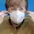 German Chancellor Angela Merkel removes a mask