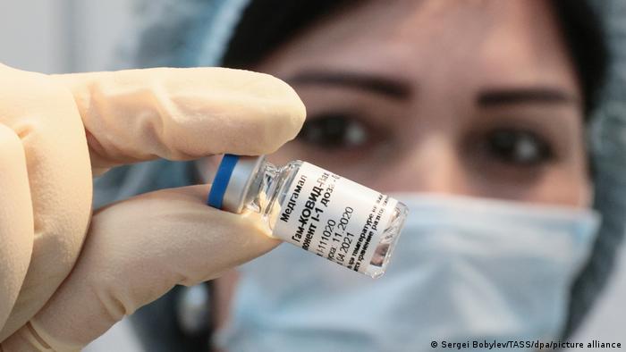 A medical worker holds an ampoule with the first component of the Gam-COVID-Vak (Sputnik V) vaccine during a COVID-19 vaccination campaign at the Mega Khimki shopping center.
