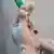 Mãos com luvas hospitalares seguram uma ampola de vacina e uma seringa
