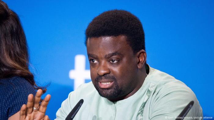  Kunle Afolayan, man seated at a microphone