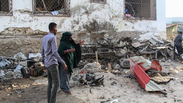 A man and a woman gesture towards rubble from the attack on the Afrik Hotel in Mogadishu