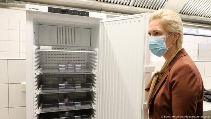 Die Ministerpräsidentin von Mecklenburg-Vorpommern, Manuela Schwesig steht mit Nase-Mund-Maske neben einem Kühlschrank, in dem der Impfstoff aufbewahrt werden soll Die Ministerpräsidentin von Mecklenburg-Vorpommern, Manuela Schwesig steht mit Nase-Mund-Maske neben einem Kühlschrank, in dem der Impfstoff aufbewahrt werden soll