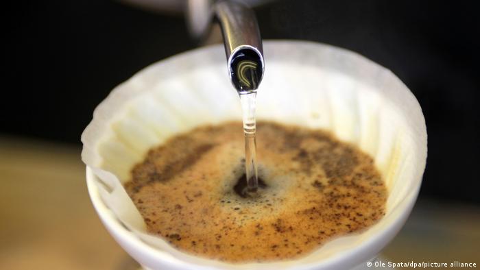 Water flowing into a cup of coffee