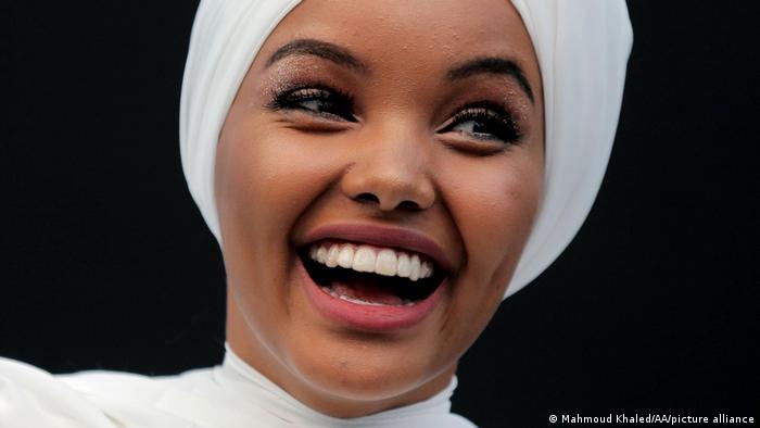 Portrait shot of Halima Aden, seen here in Dubait, 2017, in white dress and white turban-like headscarf. She left the industry in 2020.