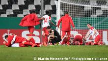 Essen's players celebrate at the end of the German Soccer Cup 3rd round match between RW Essen and Bayer Leverkusen in Essen, Germany, Tuesday, Feb. 2, 2021. (AP Photo/Martin Meissner, Pool)