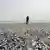 Ein Mann steht an einem Strand in Horcones in Chile, der über und über mit Fischkadavern bedeckt ist