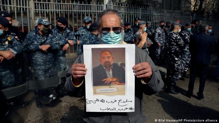 A protester holds up a picture of Lokman Slim after he was found dead in his car