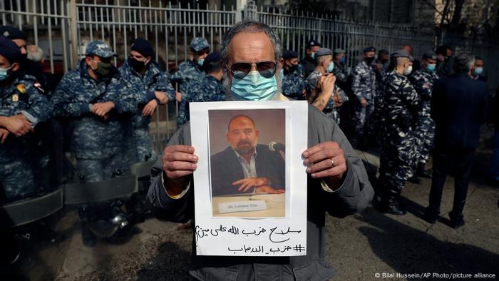 A protester holds up a picture of Lokman Slim after he was found dead in his car