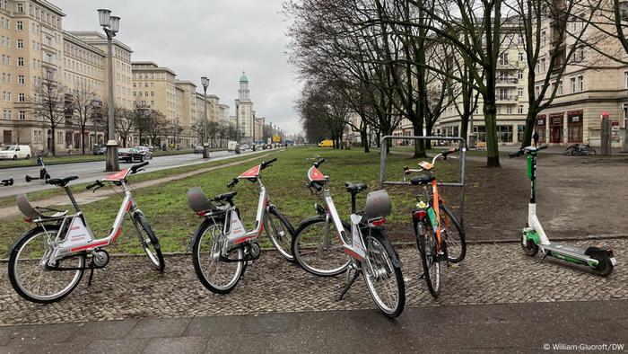 Roller und Fahrräder parkten zufällig auf einem Berliner Bürgersteig