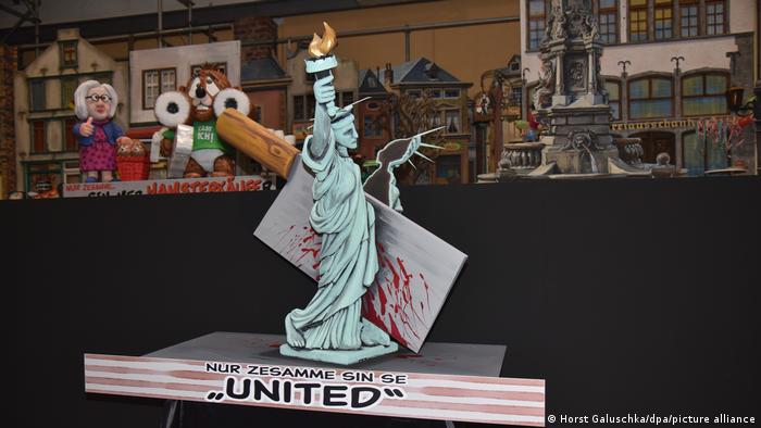 Float with a statue of liberty figure that is split in two with an ax