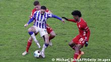 Hertha Berlin's Brazilian forward Matheus Cunha (C) vies for the ball with Bayern Munich's French forward Kingsley Coman (R) and Bayern Munich's German midfielder Joshua Kimmich during the German first division Bundesliga football match between Hertha BSC Berlin and FC Bayern Munich in Berlin on February 5, 2021. (Photo by Michael Sohn / various sources / AFP) / DFL REGULATIONS PROHIBIT ANY USE OF PHOTOGRAPHS AS IMAGE SEQUENCES AND/OR QUASI-VIDEO (Photo by MICHAEL SOHN/AFP via Getty Images)