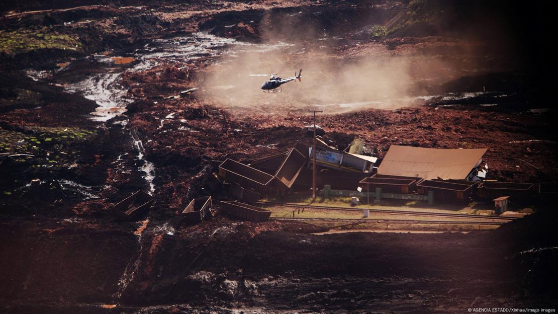 Helicóptero sobrevoa área de lama no local da tragédia