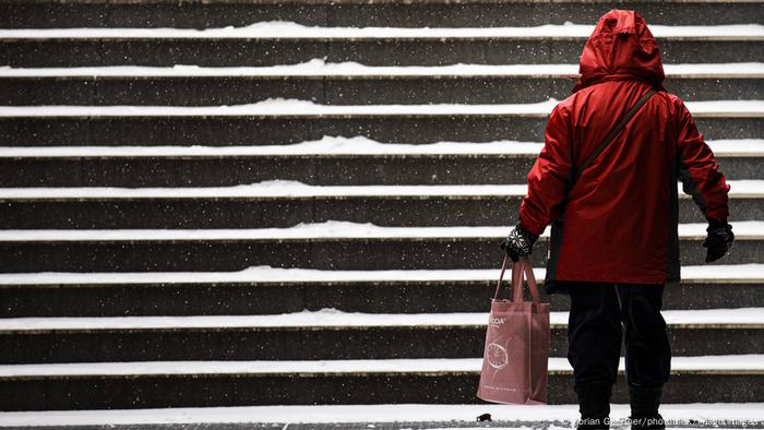 Eine Frau steht auf einer schneebedeckten Treppe in Berlin