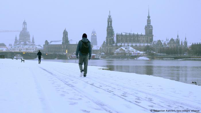 Fußgänger marschieren in Dresden entlang der Elbe