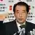 Japans Premier Naoto Kan vor einem Hintergrund mit japanischen Schriftzeichen (Foto: AP)