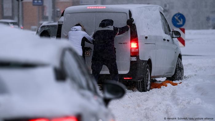 Die Leute schieben den Truck in den Schnee 