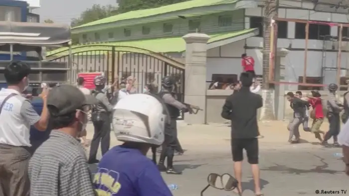 Police with rifles dispersing protesters in Myawaddy, Myanmar