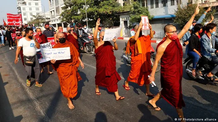 Buddhist monks marching in protest along a street in Mandaly, Myanmar