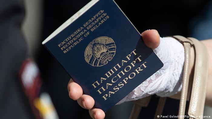 Woman holding passport of Belarus in her hand