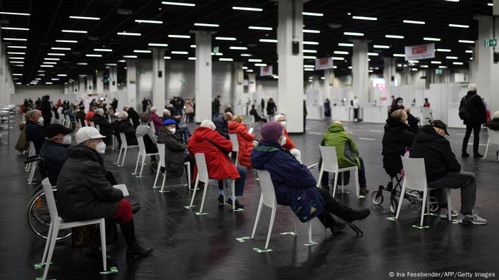 Älteste sitzen in einer Reihe in einer großen Halle und warten darauf, dass sie an die Reihe kommen