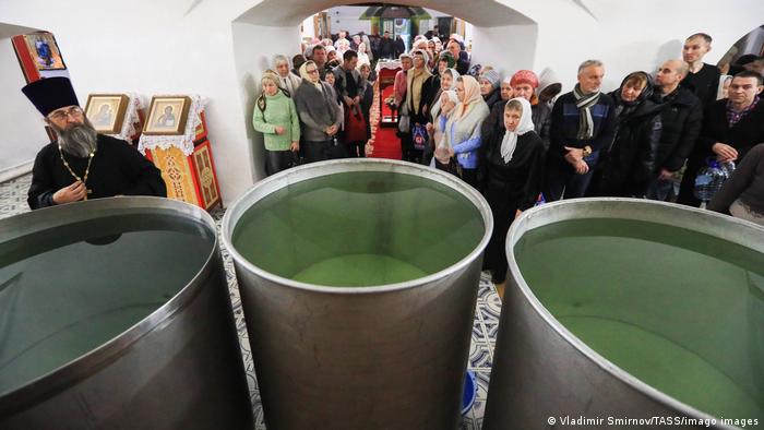 Russian Orthodox believers in front of baptismal fonts