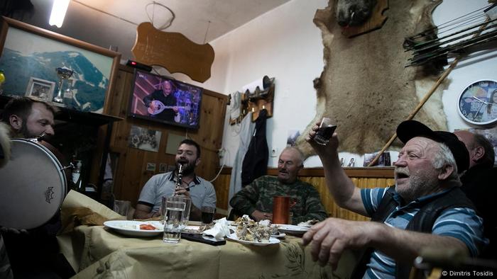 Giorgos Anthoulis celebrates with other locals in a tavern in Greece