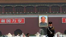 With a backdrop of a portrait of China's late communist leader Mao Zedong, center, a Chinese paramilitary policeman, right, stands still while another yawns while marching, in Tiananmen Square in Beijing, China, Friday, June 4, 2010. Chinese authorities tightened security on the vast square during the anniversary of the deadly 1989 crackdown on pro-democracy protestors, which is marked today. (AP Photo/Muhammed Muheisen)
