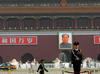 With a backdrop of a portrait of China's late communist leader Mao Zedong, center, a Chinese paramilitary policeman, right, stands still while another yawns while marching, in Tiananmen Square in Beijing, China, Friday, June 4, 2010. Chinese authorities tightened security on the vast square during the anniversary of the deadly 1989 crackdown on pro-democracy protestors, which is marked today. (AP Photo/Muhammed Muheisen)