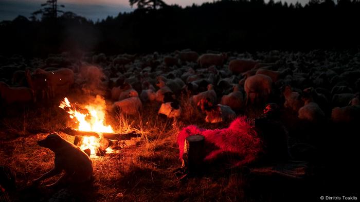 Giannis Saitis gets ready for bed beside a fire in the open 