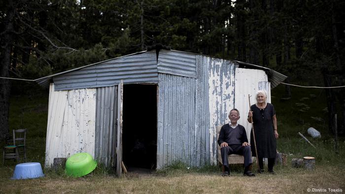 Elini Tzima and her husband Nasos Tzimas stand outside a shed in Greece