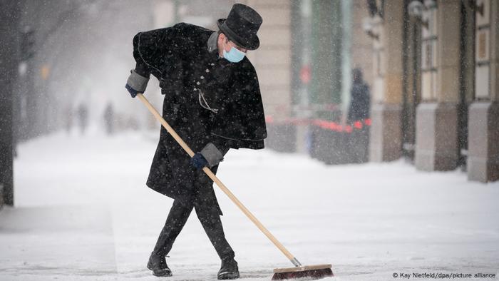 Hotel worker sweeping snow in Berlin