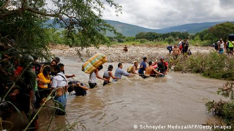Paso de migrantes venezolanos a través de una trocha, un camino no oficial hacia Colombia