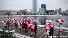 A group of people hold umbrellas in colors of old Belarusian national flag during an opposition action to protest the official presidential election results in Minsk, Belarus, Wednesday, Jan. 6, 2021. Winter's cold and harsh police have put a chill on the protests against President Alexander Lukashenko that gripped Belarus for months. But opposition forces are preparing to turn up the heat in the spring and observers say Lukashenko doesn't have a clear strategy to overcome new unrest. (AP Photo, File)