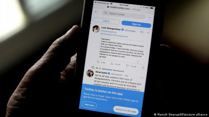 A man reads tweets by Indian celebrities, one of the many backing the Indian government