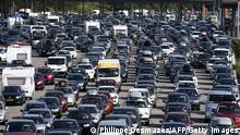 TOPSHOT - Motorists queue in their vehicles at a toll station on the A7 motorway near Vienne, southeastern France, on August 4, 2018, during a heavy traffic jam on the first major weekend of the French summer holidays. - This weekend is expected to be most difficult of the summer for traffic, with hundreds of kilometers of traffic jams, as holiday-makers start or end their holidays. The A7, also known as the Autoroute du soleil (the Sun's motorway), links Paris to the French Mediterranean coast (Photo by PHILIPPE DESMAZES / AFP) (Photo credit should read PHILIPPE DESMAZES/AFP via Getty Images)