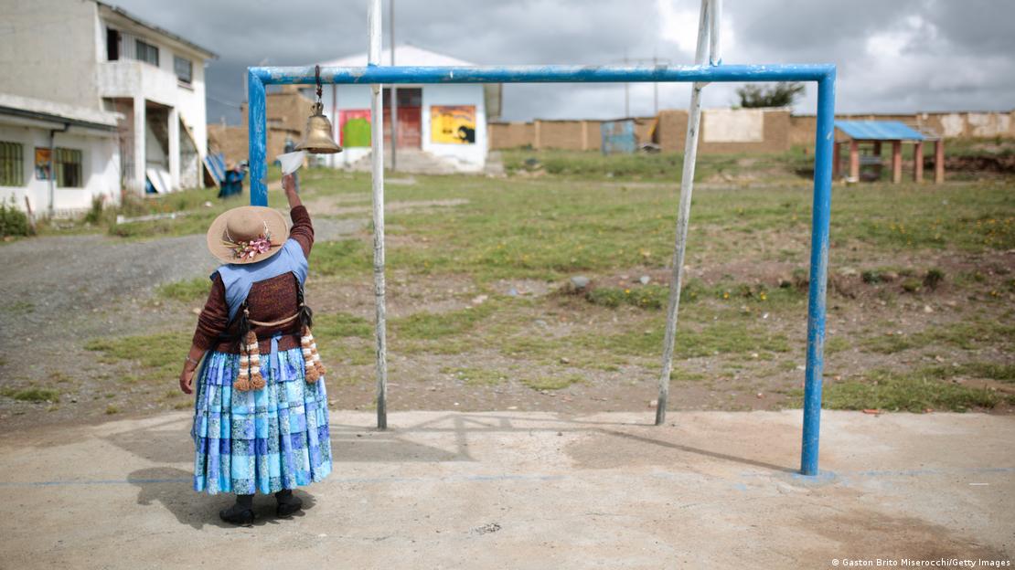 Foto simbólica de una persona que toca una campana en una escuela de Bolivia