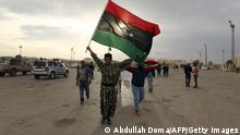 Libyan men wave their national flag during a demonstration marking the fifth anniversary of the Libyan revolution, which toppled strongman Moamer Kadhafi, in the city of Benghazi, the 2011 uprising's birthplace, some 1,000 kilometres east of Tripoli, on February 17, 2016.
Unlike the capital Tripoli, celebrations did not reach Benghazi, where war has raged for two years between the Libyan army and armed groups including Islamists.
/ AFP / ABDULLAH DOMA (Photo credit should read ABDULLAH DOMA/AFP via Getty Images)