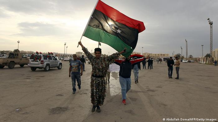 Un militar sostiene una bandera libia en Benghazi.