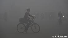 TOPSHOT - A boy rides a bike to school amid heavy smog conditions in Lahore on February 12, 2021.  (Photo by Arif ALI / AFP)