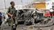 A member of the security forces walks past wreckage at the scene of a bombing in Mogadishu, Somalia. A member of the security forces walks past wreckage at the scene of a bombing in Mogadishu, Somalia.