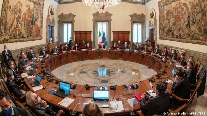 Regierungsmitglieder an einem runden Tisch in einem historischen Saal