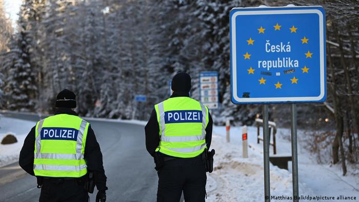 Border police stand before an EU-Czech Republic signpost