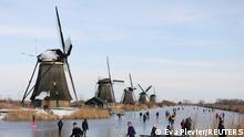 People ice skate during a cold snap across the country along the windmills in Kinderdijk, Netherlands February 14, 2021. REUTERS/Eva Plevier 