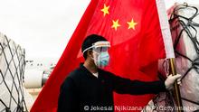 15.02.21 *** A man wearing a face mask holds the Chinese national flag as he looks on while workers offload an Air Zimbabwe aeroplane with a donation of 200,000 doses of the Sinopharm coronavirus vaccine from China on February 15, 2021 at the Robert Mugabe International Airport. (Photo by Jekesai NJIKIZANA / AFP) / The erroneous mention[s] appearing in the metadata of this photo by Jekesai NJIKIZANA has been modified in AFP systems in the following manner: [February 15, 2021] instead of [January 15, 2021]. Please immediately remove the erroneous mention[s] from all your online services and delete it (them) from your servers. If you have been authorized by AFP to distribute it (them) to third parties, please ensure that the same actions are carried out by them. Failure to promptly comply with these instructions will entail liability on your part for any continued or post notification usage. Therefore we thank you very much for all your attention and prompt action. We are sorry for the inconvenience this notification may cause and remain at your disposal for any further information you may require. (Photo by JEKESAI NJIKIZANA/AFP via Getty Images)