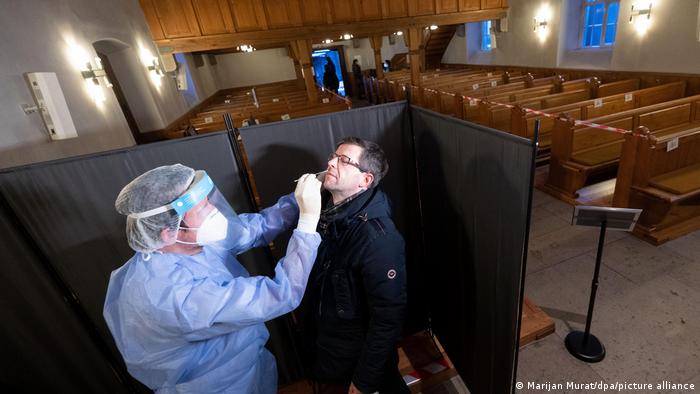 A man is tested for COVID in a repurposed church