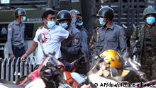 Police arresting a man during protests in Mandalay