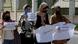 Women hold signs during a protest against the decision banning women from travel in and out of the Gaza Strip without the permission of her "guardian". Women hold signs during a protest against the decision banning women from travel in and out of the Gaza Strip without the permission of her "guardian".