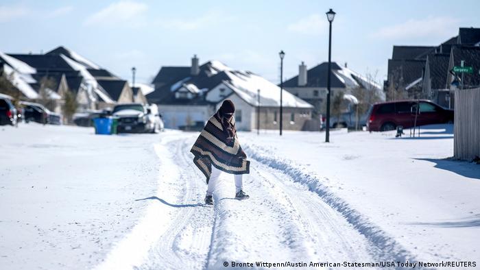 Homem caminha em Pflugerville, no Texas, sobre camada de neve